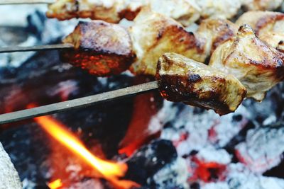 Close-up of meat in skewer on barbecue grill