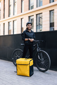 Delivery person using mobile phone by bicycle