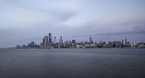 Buildings in city against cloudy sky