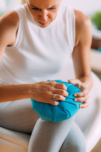 Knee pain treatment. woman holding an ice bag pack on her painful knee