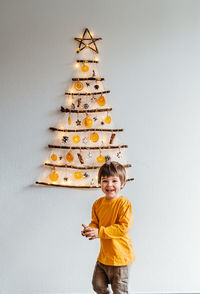 Full length of boy standing against wall