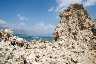 Rock formation on beach against sky