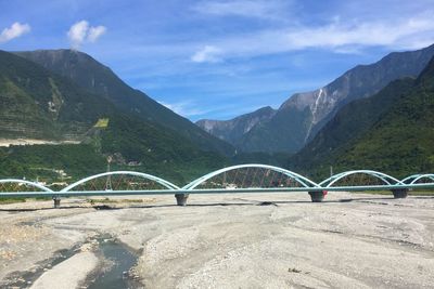 Bridge over mountains against sky