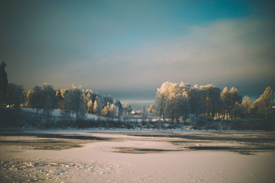 Scenic view of lake against sky during winter