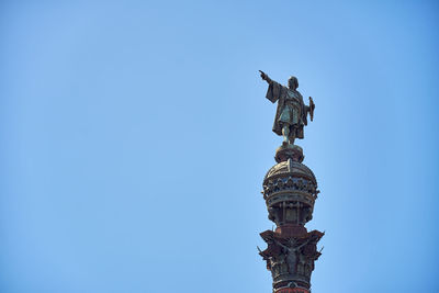 Low angle view of statue against blue sky