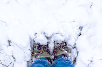 Female feet in winter boots standing in a snowdrift of fresh snow. winter walk, copy space