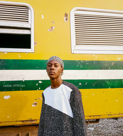 Portrait of a young man standing against a train