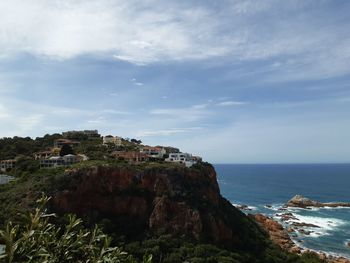 Scenic view of sea by buildings against sky