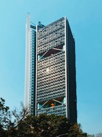 Low angle view of modern building against clear blue sky