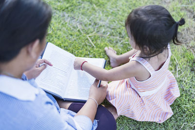 Side view of young woman using laptop at park