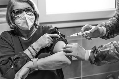 Cropped hands of doctor giving injection to patient