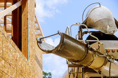 Low angle view of old metal structure against sky