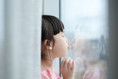 Portrait of woman looking through window