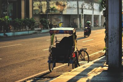 Riskshaw and motorcycle on road