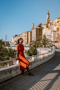 Woman with umbrella against sky