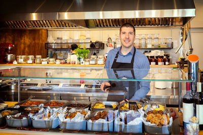 Portrait of smiling owner standing in store