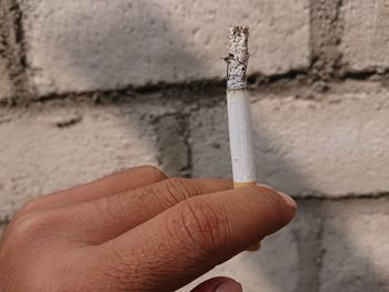 Close-up of hand holding cigarette