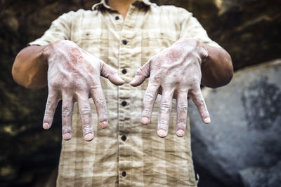 Midsection of man with messy hands at campsite