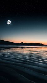 Scenic view of lake against sky at night