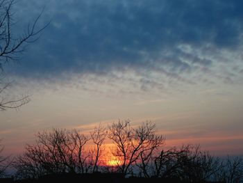 Low angle view of silhouette bare trees against romantic sky