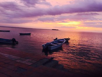 High angle view of boats in sea against cloudy sky during sunset