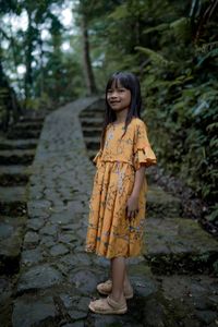 Portrait of young woman standing on steps