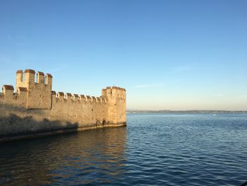 View of fort on sea against blue sky