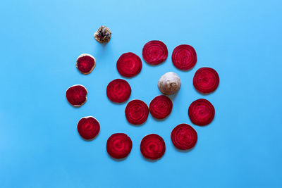 High angle view of red berries against blue background