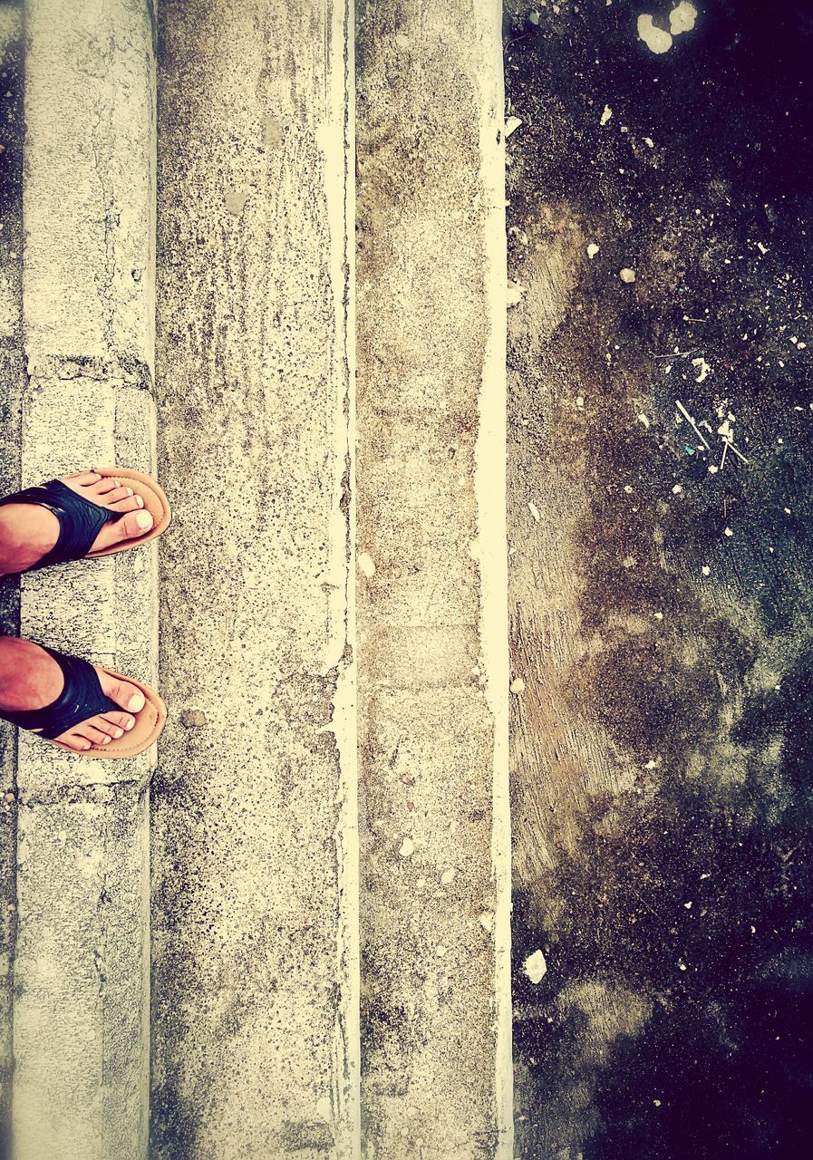 LOW SECTION OF WOMAN STANDING ON ASPHALT