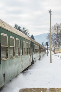 Train on snow covered landscape against sky