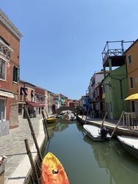 Canal amidst buildings against sky