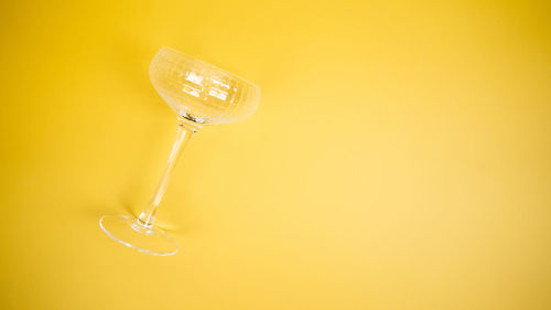 A coupe glass on a bright yellow background