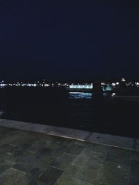 Illuminated sea against sky at night