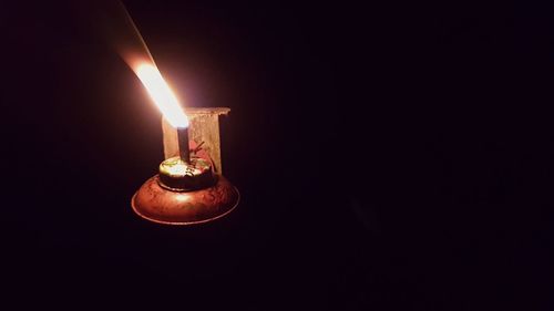 Close-up of lit candle in the dark
