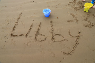 High angle view of text on sand at beach