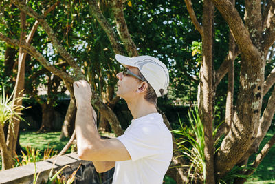 Side view of man standing by trees