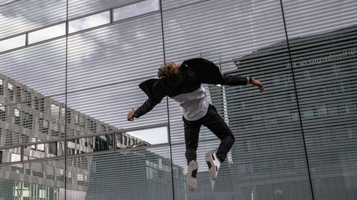 Full length of man jumping on railing in city