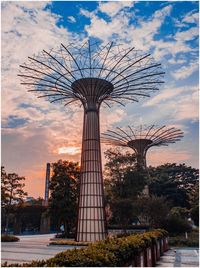 Low angle view of ferris wheel against cloudy sky