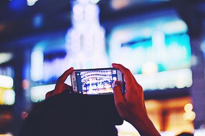 Close-up of hand using mobile phone at music concert