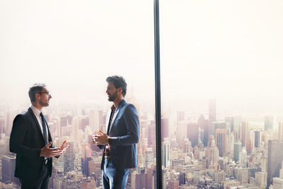 Businessmen having discussion by window in office