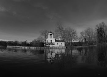 Houses by lake against sky
