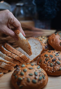 Close-up of hand holding bread on table