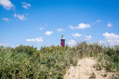 Lighthouse by sea against sky