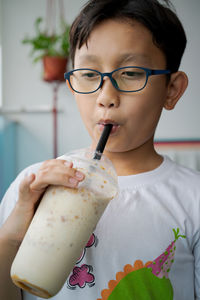 Boy drinking smoothie at home