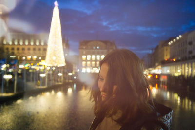 Portrait of woman in city at night