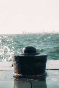 Close-up of metal ship in sea against sky