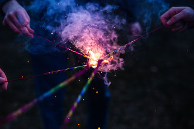 Person holding sparkler at night