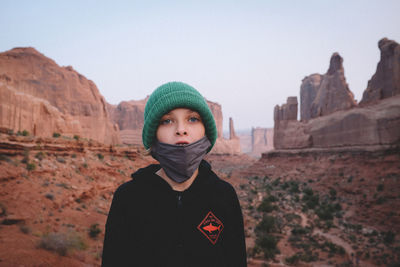 Portrait of man standing in park against sky during winter