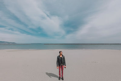 Full length of man standing on beach against sky