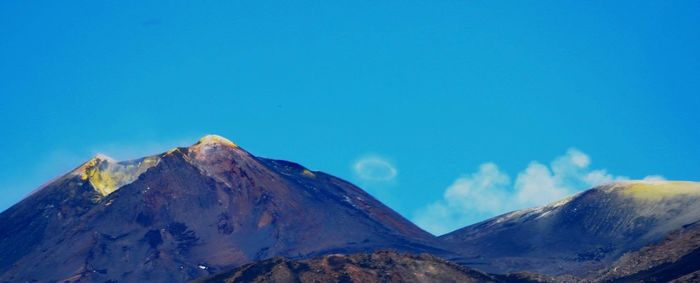 Low angle view of mountains against blue sky